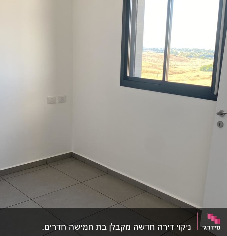 חדר ריק עם רצפת אריחים נקייה וקירות לבנים